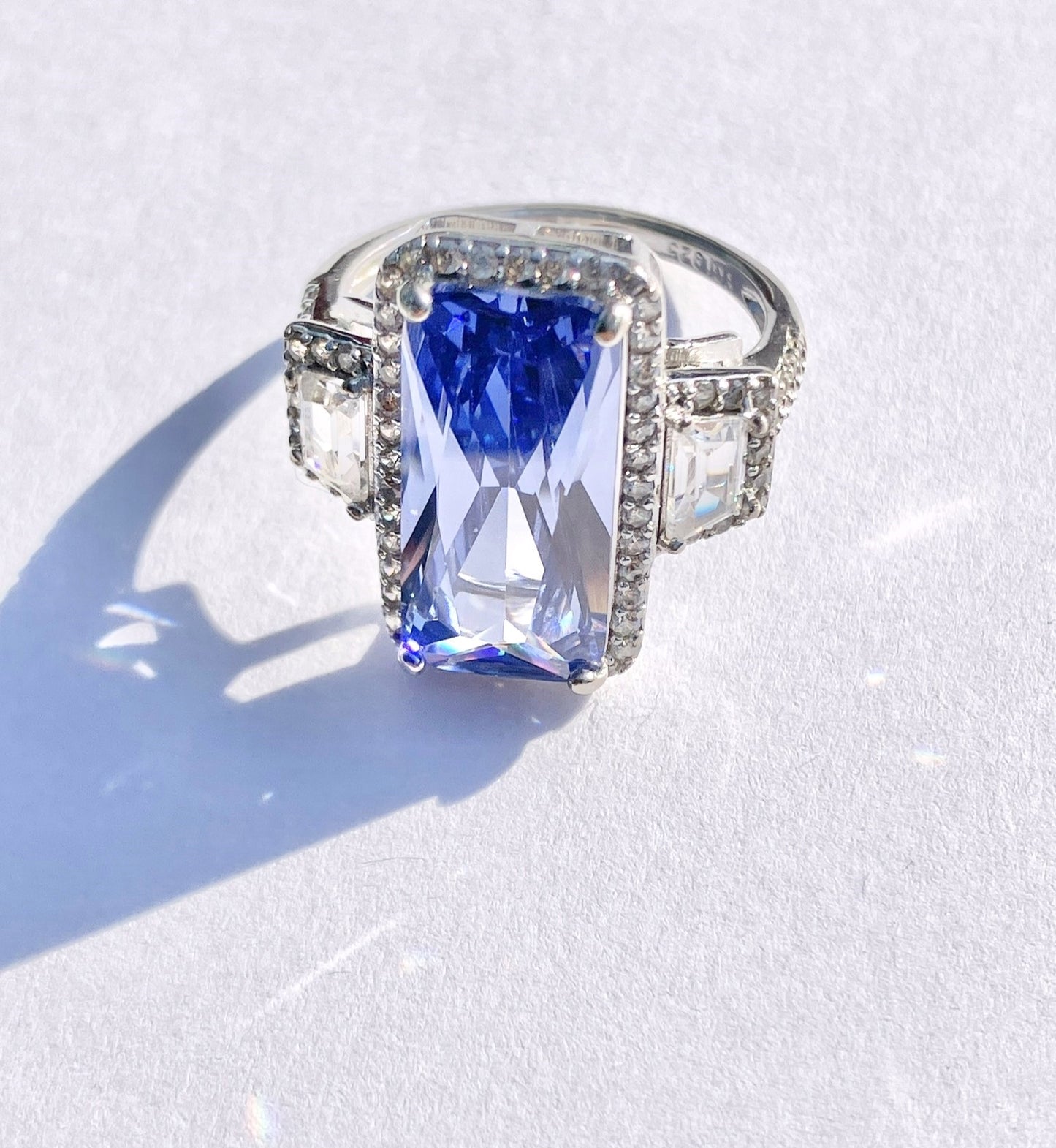 Periwinkle “Sapphire” in “Diamond” Halo with Trapezoid Cut “Diamond” Accents