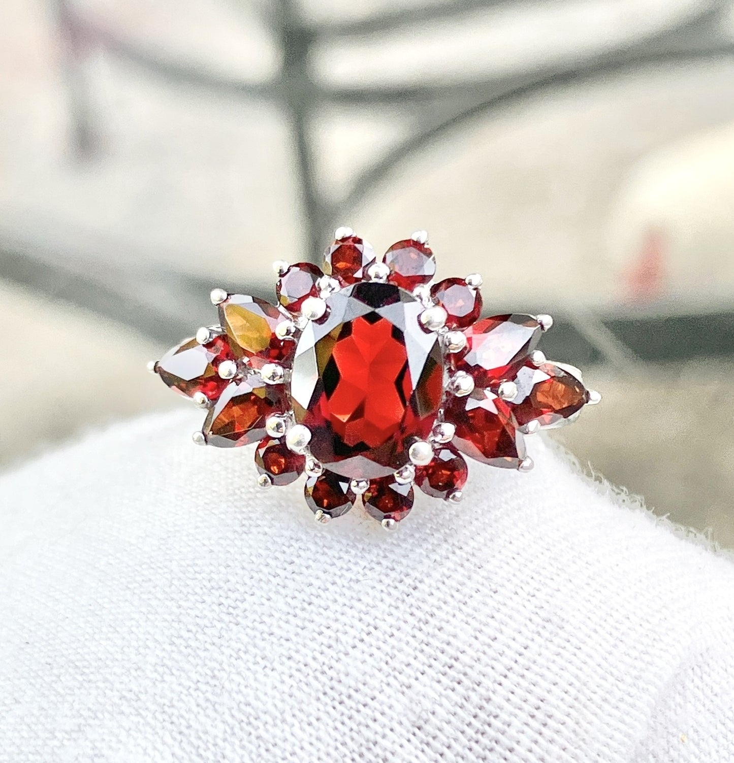 Oval Cut Garnet in a Pear and Round Cut Garnet Halo Ring