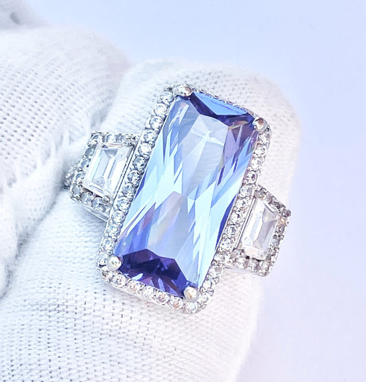 Periwinkle “Sapphire” in “Diamond” Halo with Trapezoid Cut “Diamond” Accents